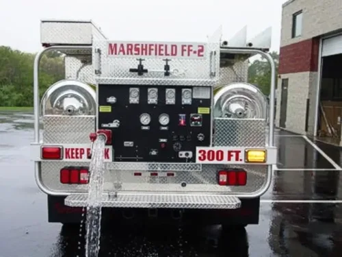 Exterior view of small fire truck showing cab, body compartments, and wheel/tire area.