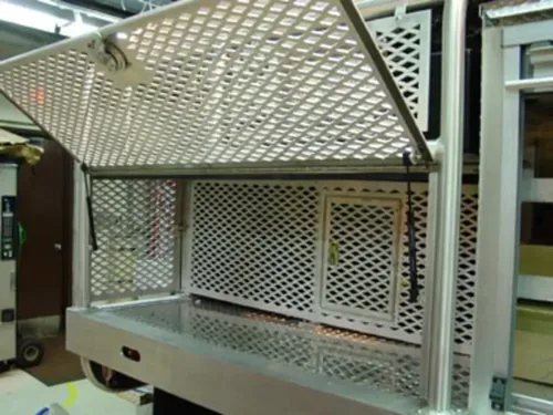 Exterior view of small fire truck showing cab, body compartments, and wheel/tire area.