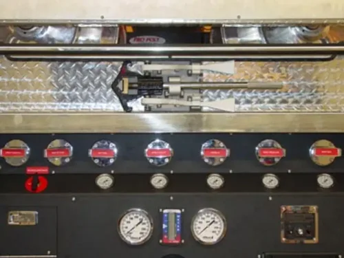 Exterior view of small fire truck showing cab, body compartments, and wheel/tire area.
