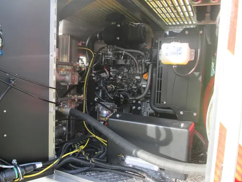 Exterior view of small fire truck showing cab, body compartments, and wheel/tire area.