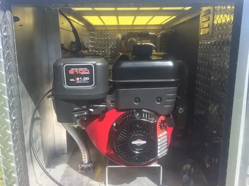 Exterior view of small fire truck showing cab, body compartments, and wheel/tire area.