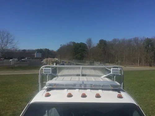 Exterior view of small fire truck showing cab, body compartments, and wheel/tire area.
