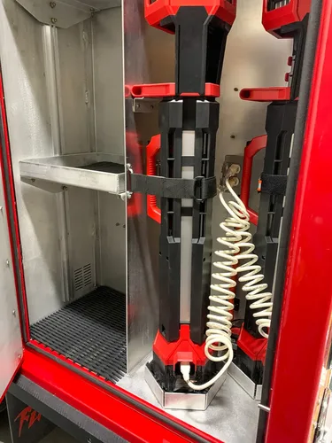 Exterior view of small fire truck showing cab, body compartments, and wheel/tire area.