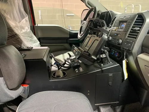 Exterior view of small fire truck showing cab, body compartments, and wheel/tire area.