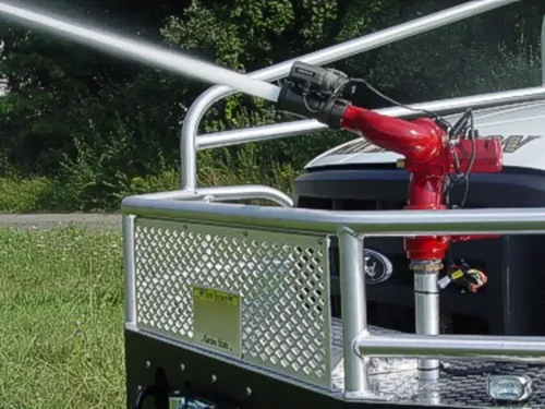 Exterior view of small fire truck showing cab, body compartments, and wheel/tire area.