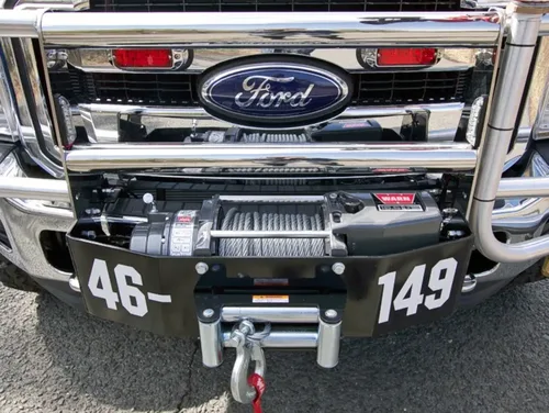 Exterior view of small fire truck showing cab, body compartments, and wheel/tire area.