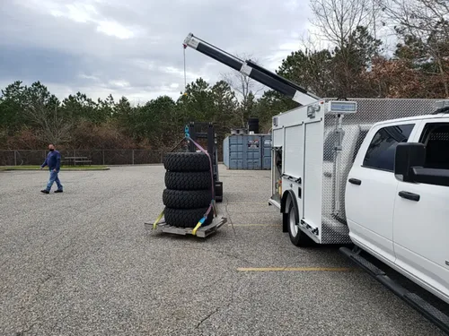 Exterior view of small fire truck showing cab, body compartments, and wheel/tire area.
