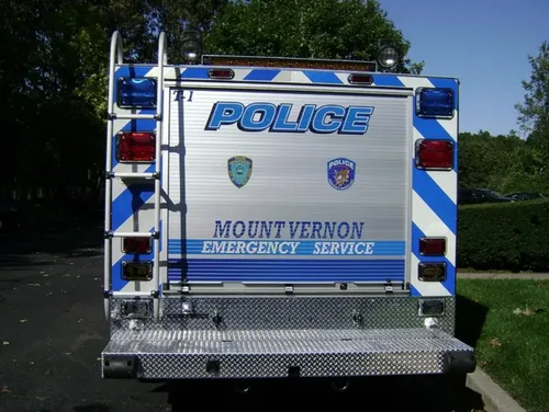 Exterior view of small fire truck showing cab, body compartments, and wheel/tire area.