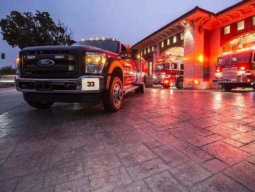Exterior view of small fire truck showing cab, body compartments, and wheel/tire area.