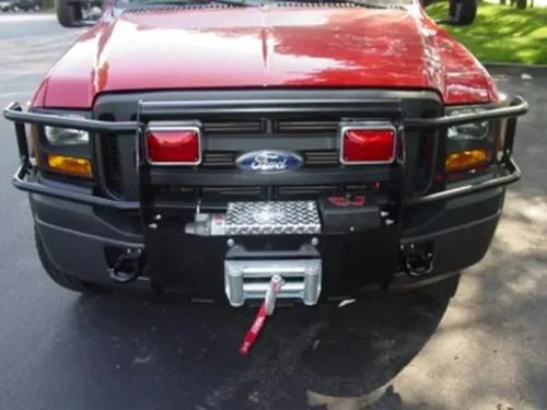 Exterior view of small fire truck showing cab, body compartments, and wheel/tire area.