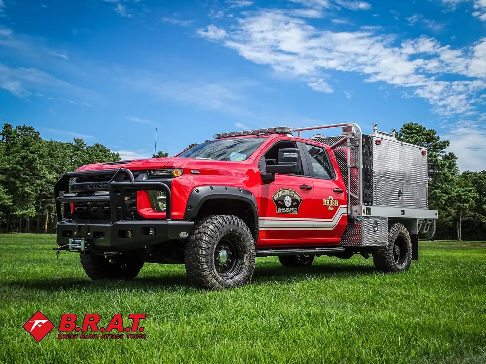 Exterior view of small fire truck showing cab, body compartments, and wheel/tire area.