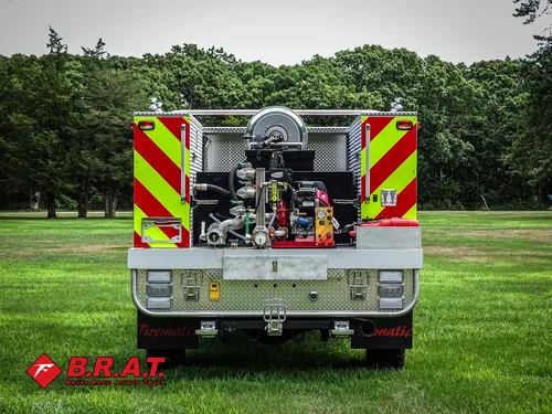 Exterior view of small fire truck showing cab, body compartments, and wheel/tire area.