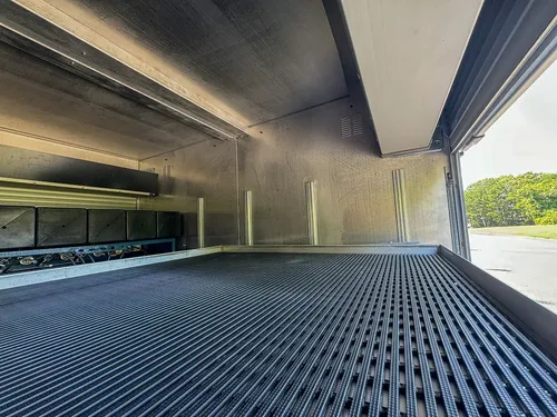 Wide compartment interior showing low ceiling shelf and ribbed floor.