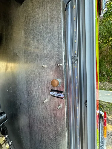 Interior compartment wall close-up with small labeled controls.
