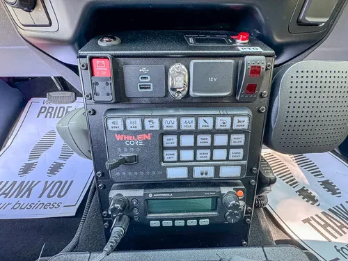 Center console close-up with radio stack and Whelen control keypad.
