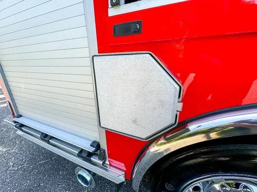 Small octagonal side hatch closed near wheel arch and roll-up door.