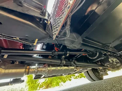 Underside detail with suspension and drivetrain components visible.