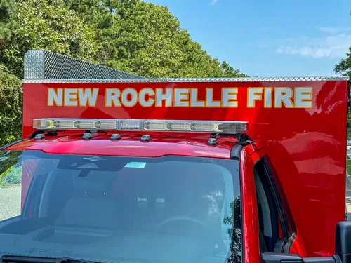 Cab roof and front body sign close-up reading New Rochelle Fire.