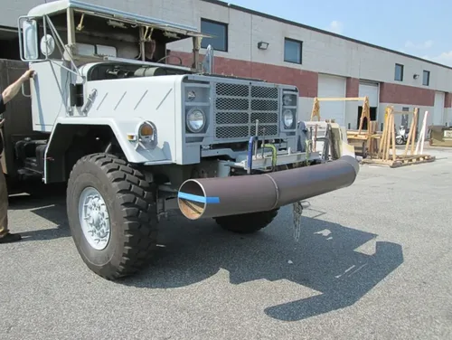 Exterior view of small fire truck showing cab, body compartments, and wheel/tire area.
