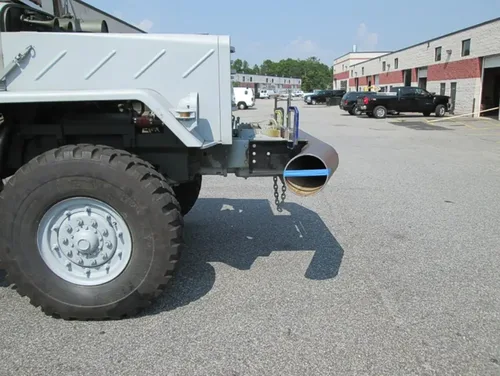 Exterior view of small fire truck showing cab, body compartments, and wheel/tire area.