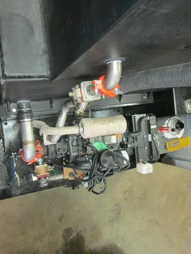 Exterior view of small fire truck showing cab, body compartments, and wheel/tire area.