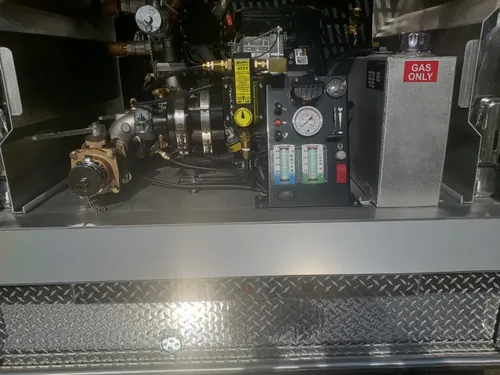 Exterior view of small fire truck showing cab, body compartments, and wheel/tire area.