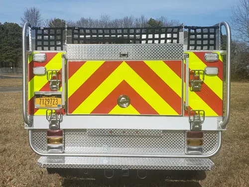 Exterior view of small fire truck showing cab, body compartments, and wheel/tire area.