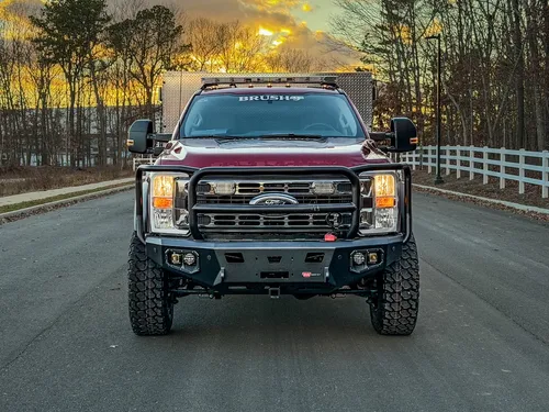 Head-on front view with grille guard and heavy-duty bumper.