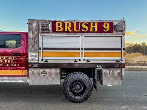 Mid-body side view with BRUSH 9 lettering above roll-up doors.