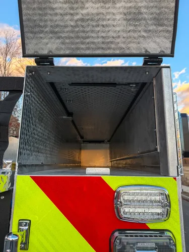Open rear tunnel compartment with interior light on.