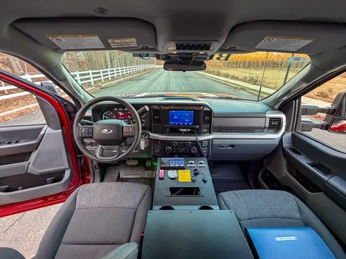 Wide cockpit view from rear seat toward dashboard and console.