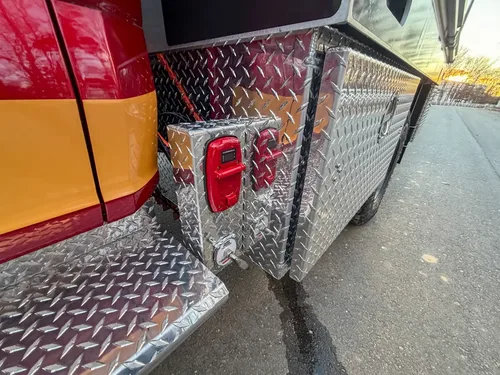 Rear side corner with diamond-plate panel and marker light.