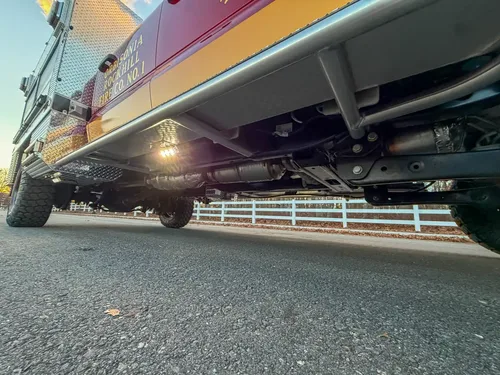 Underbody side profile with frame rails and running gear.