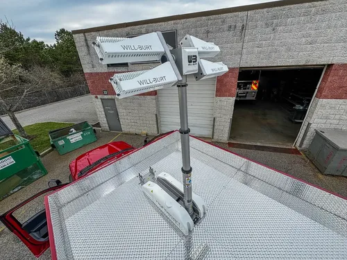 Exterior view of small fire truck showing cab, body compartments, and wheel/tire area.