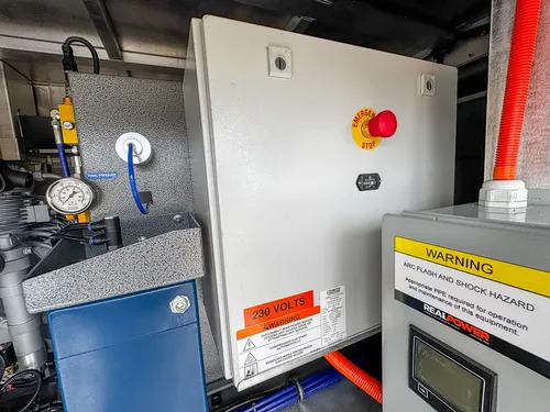 Close view of 230-volt electrical enclosure and adjacent components.