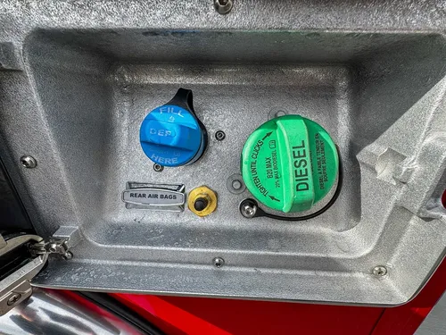 Close detail of DEF and diesel fill points inside access panel.