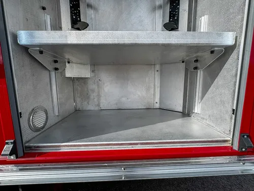 Lower shelf area inside tall rear-side compartment.