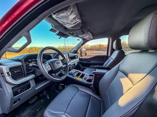 Wide interior view from driver side with front seats, dashboard, and center console.