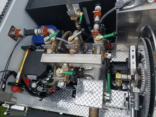 Exterior view of small fire truck showing cab, body compartments, and wheel/tire area.
