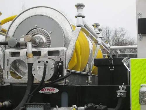 Exterior view of small fire truck showing cab, body compartments, and wheel/tire area.