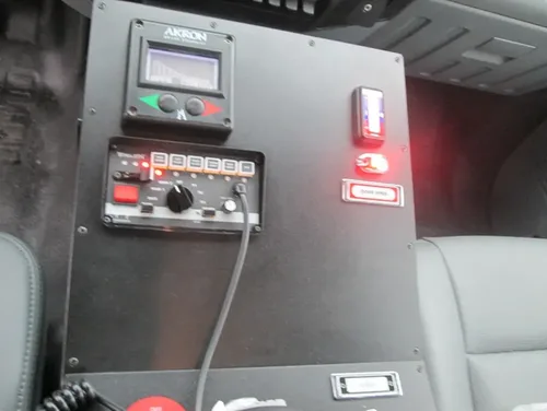 Exterior view of small fire truck showing cab, body compartments, and wheel/tire area.