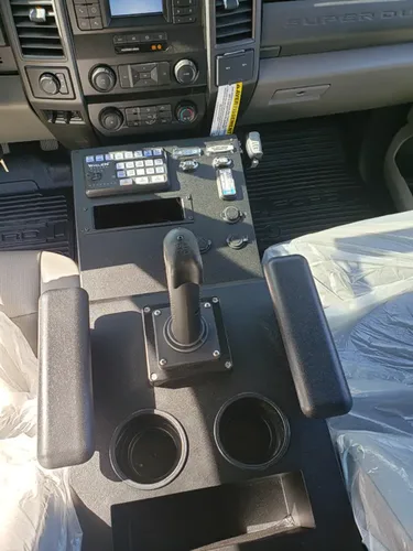Exterior view of small fire truck showing cab, body compartments, and wheel/tire area.