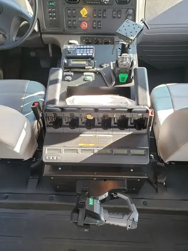 Exterior view of small fire truck showing cab, body compartments, and wheel/tire area.