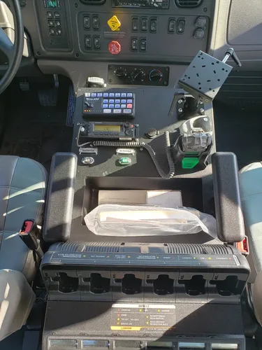 Exterior view of small fire truck showing cab, body compartments, and wheel/tire area.