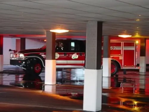Exterior view of small fire truck showing cab, body compartments, and wheel/tire area.