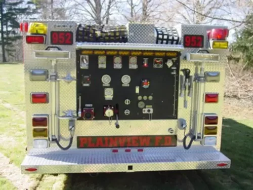Exterior view of small fire truck showing cab, body compartments, and wheel/tire area.