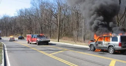 Exterior view of small fire truck showing cab, body compartments, and wheel/tire area.