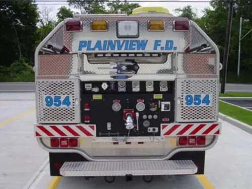 Exterior view of small fire truck showing cab, body compartments, and wheel/tire area.