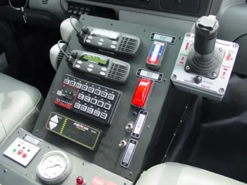 Exterior view of small fire truck showing cab, body compartments, and wheel/tire area.