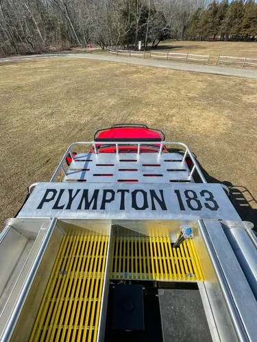 Exterior view of small fire truck showing cab, body compartments, and wheel/tire area.